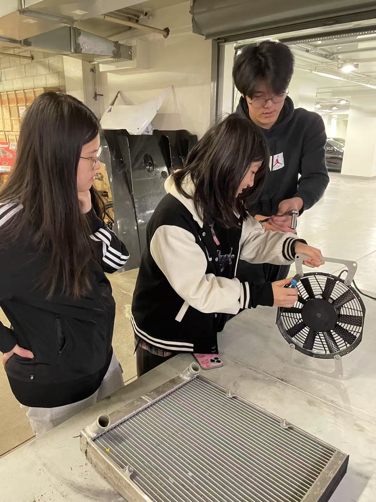 Students assembling radiator and fan components together