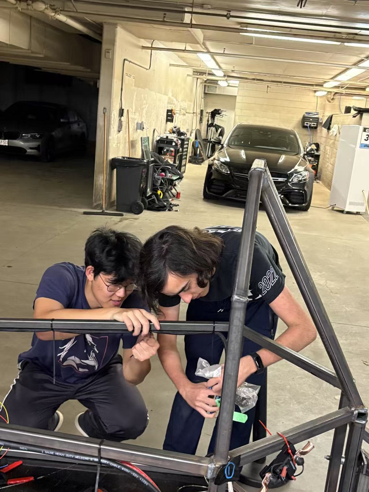 Two students assembling the EV chassis frame