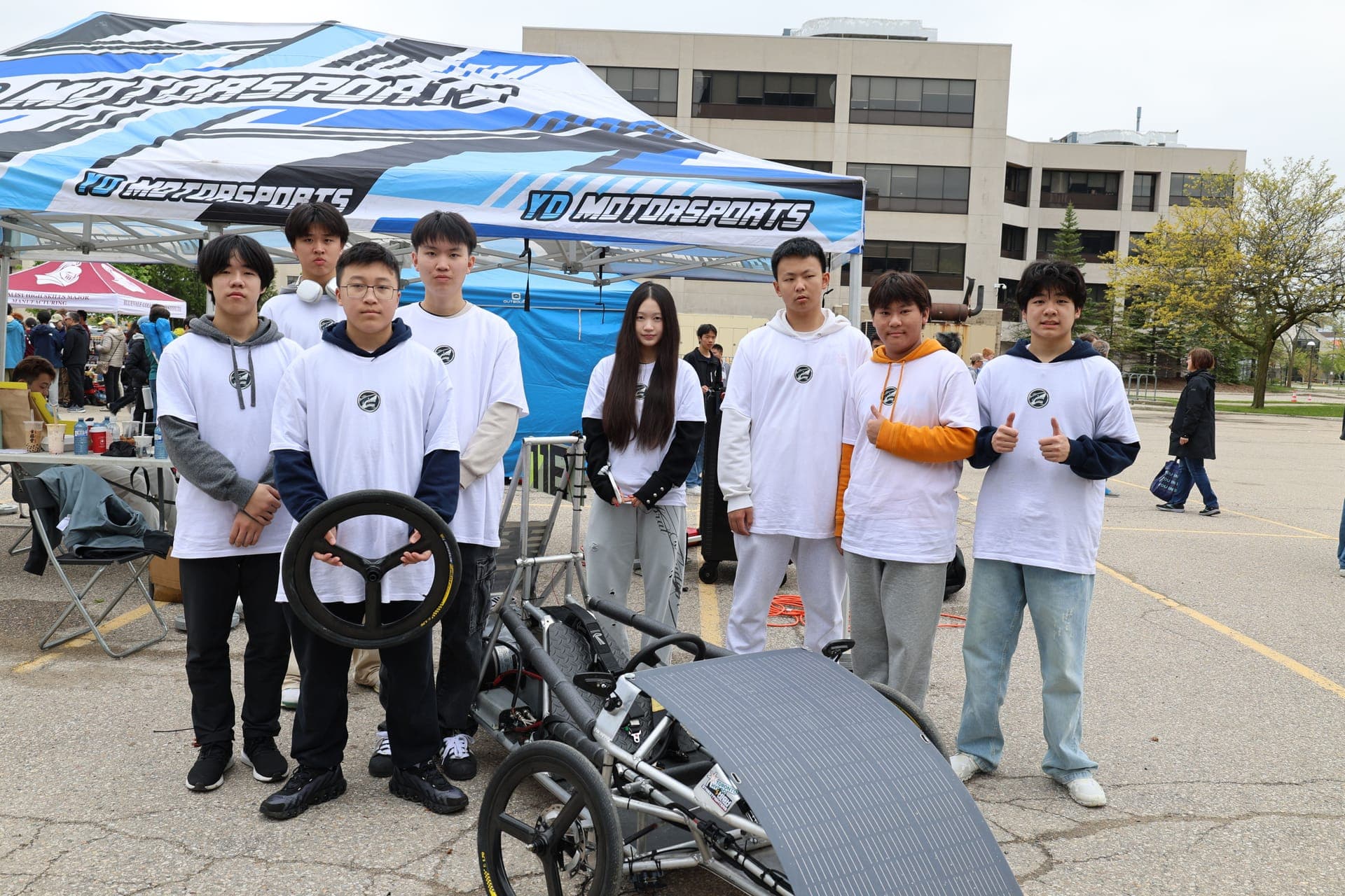 Ithaca EV team members with their vehicle at competition
